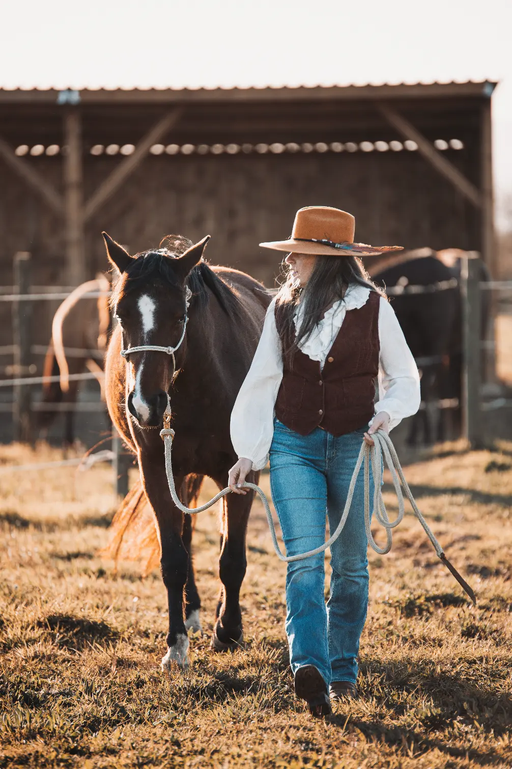 Femme marchant avec son cheval au ranch