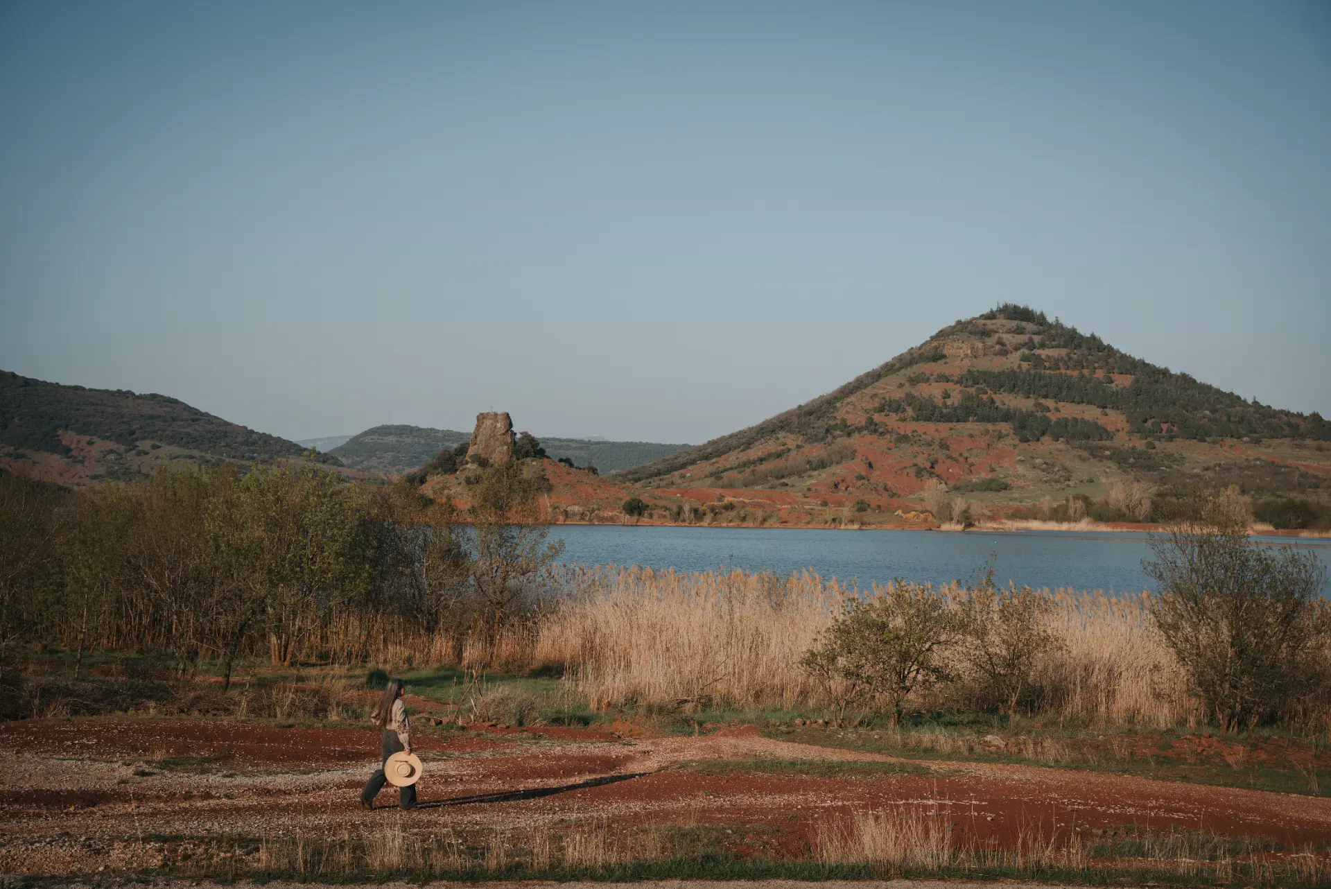 Fanny marchant vers un lac entouré de collines