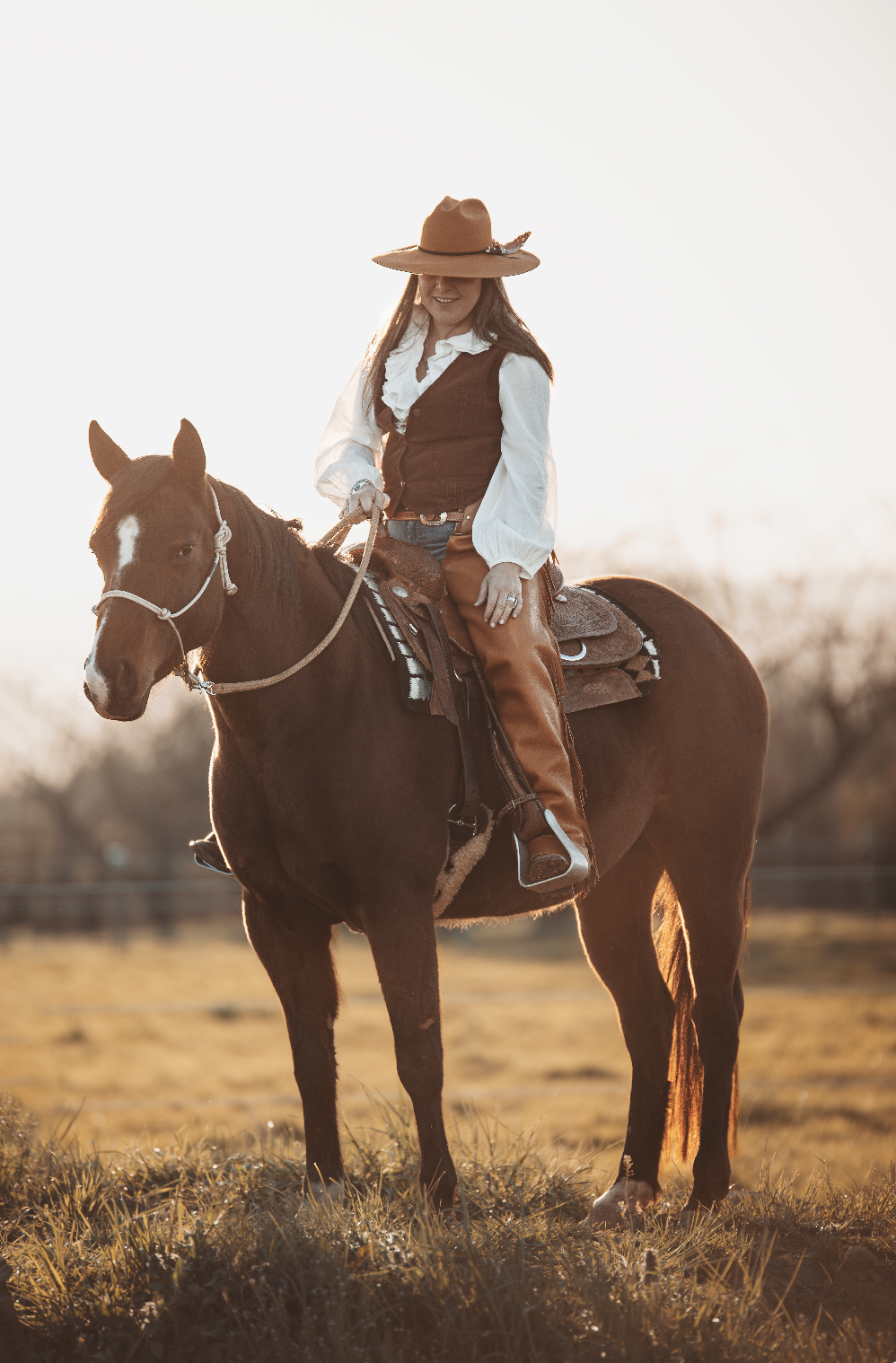 Cavalière western sur son cheval au lever du jour
